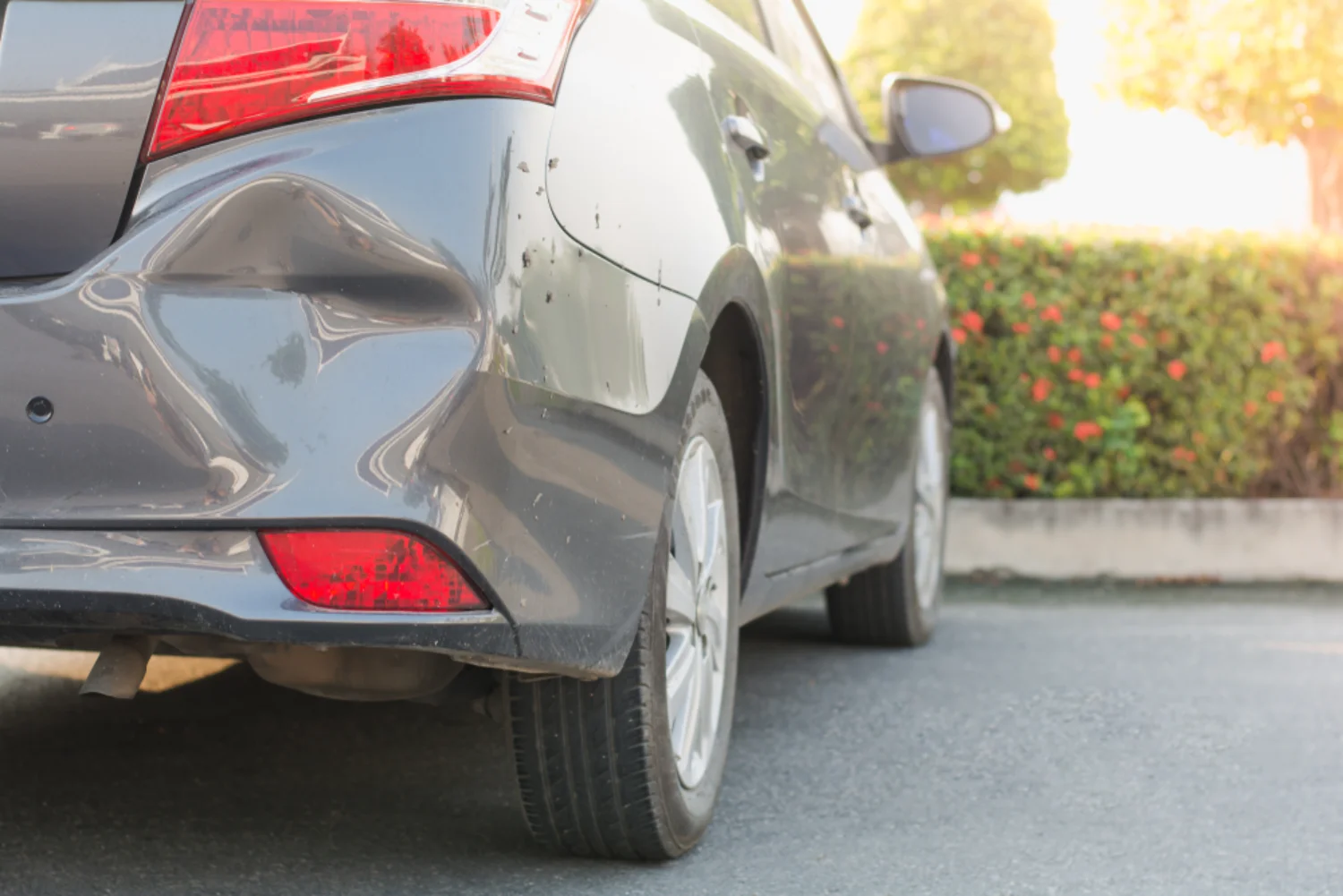 Smash damage to the rear corner of a dark hatchback requiring a panel beating repair